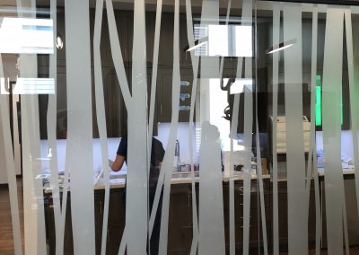 White window film on floor to ceiling glass cut into tree bark pattern