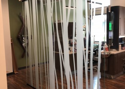 White window film on floor to ceiling glass cut into tree bark pattern