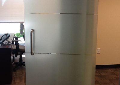 Three white frost bands installed on the middle of a glass door