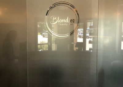 Solyx Clear Sand Blast designer window film with beauty shop logo cut out of it