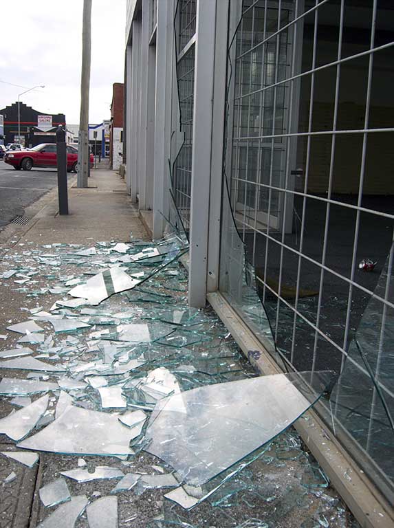Large sharp pieces of glass on the ground from large broken windows