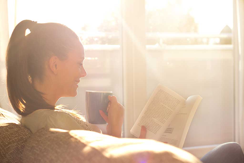 Women sitting on couch reading in blinding sunlight